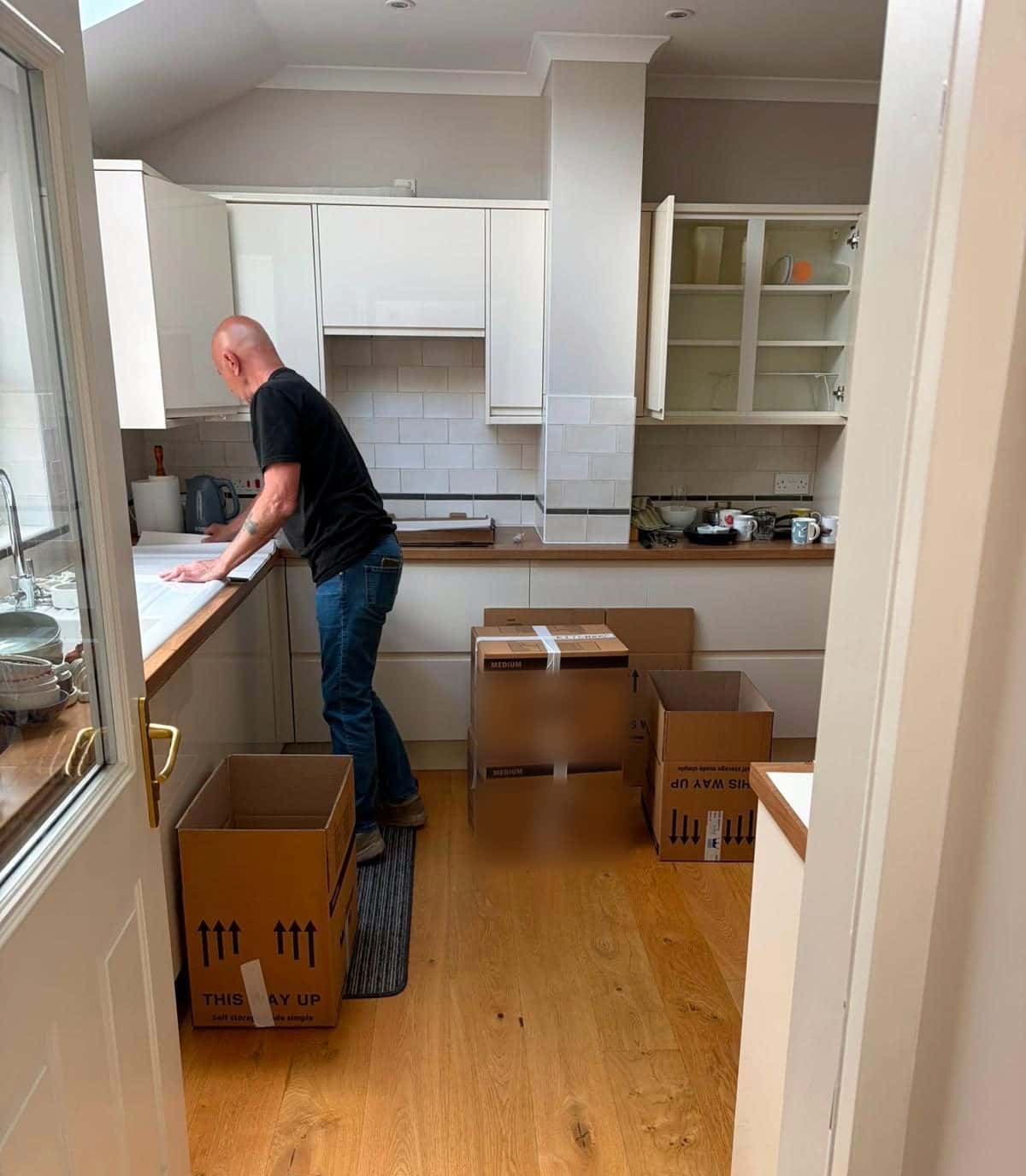 Duffield packer boxing up a kitchen, cartons on the oak floor