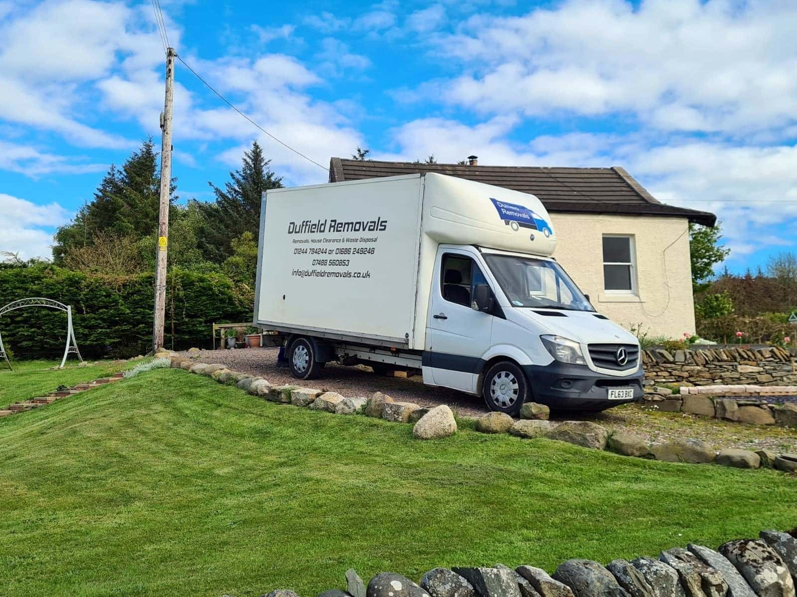 Duffield Mercedes Luton van beside a white cottage, stone wall and lawn