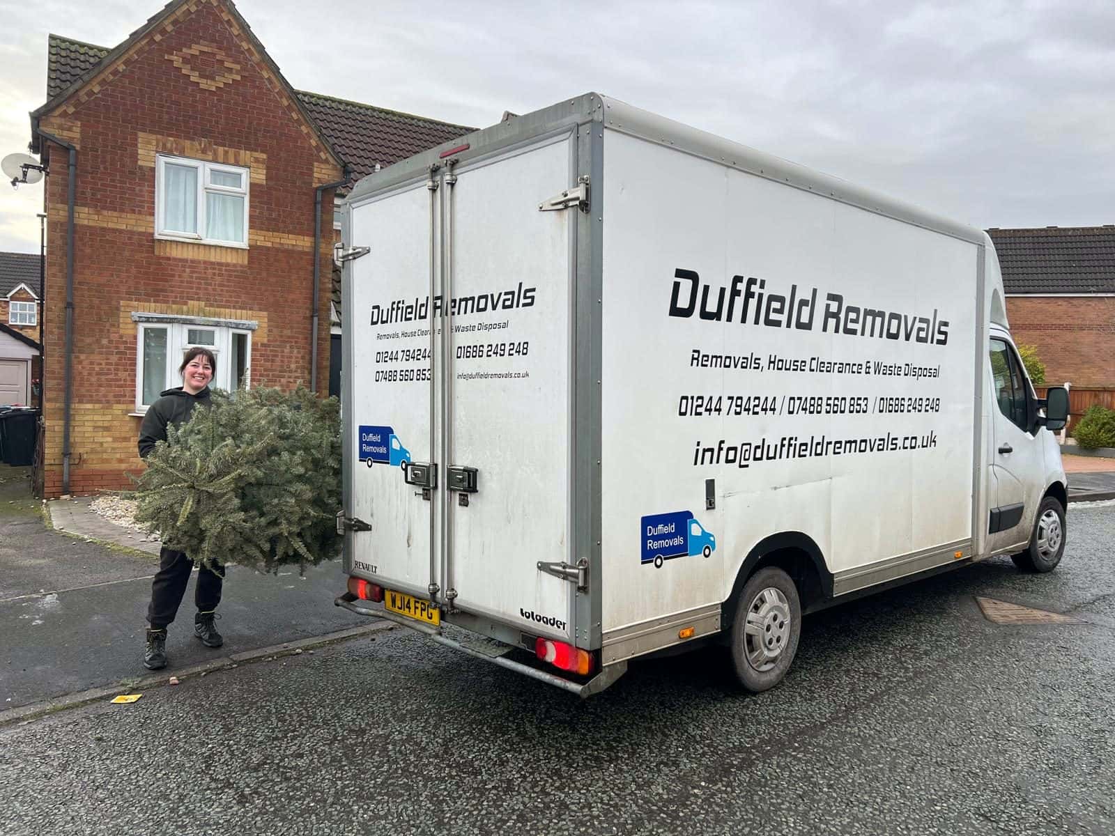 Leanne carrying a Christmas tree to a Duffield Removals van