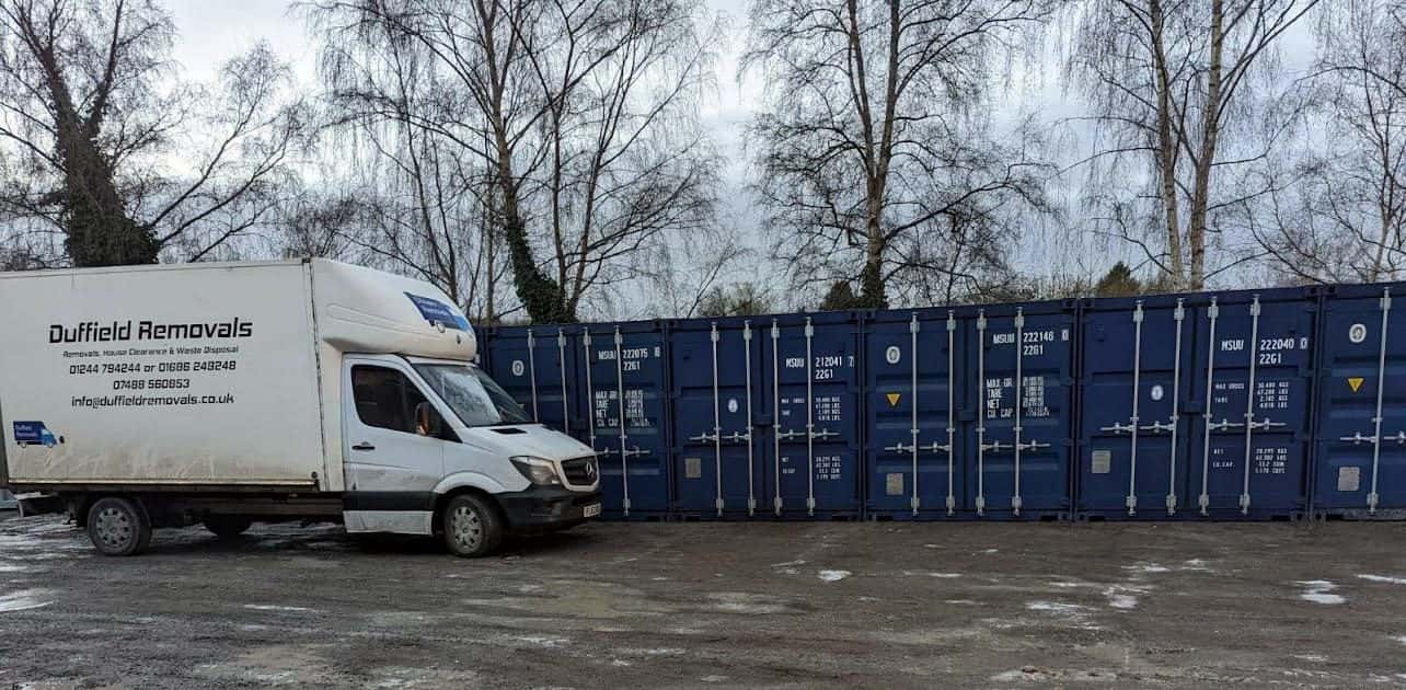 Duffield van next to a row of blue storage containers in snow at Rhayader