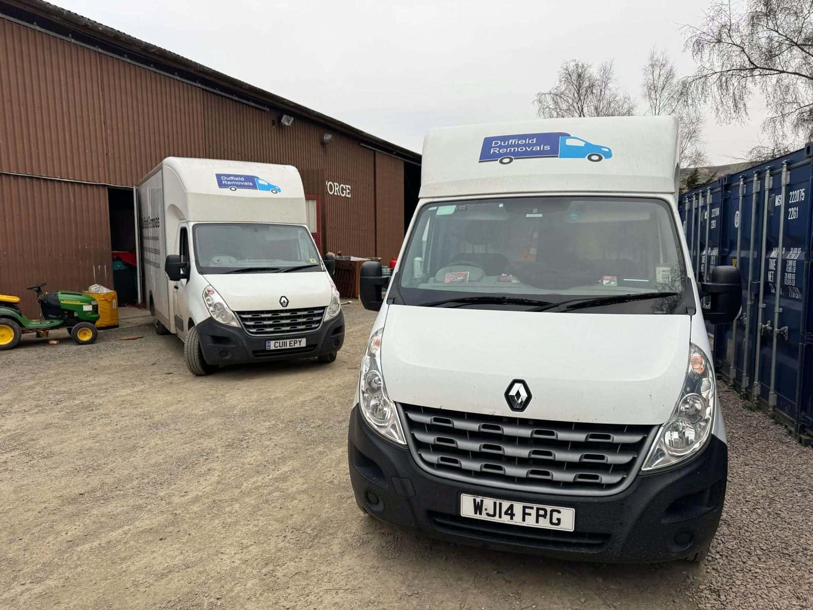 Two Duffield vans by THE FORGE warehouse and blue containers at Rhayader