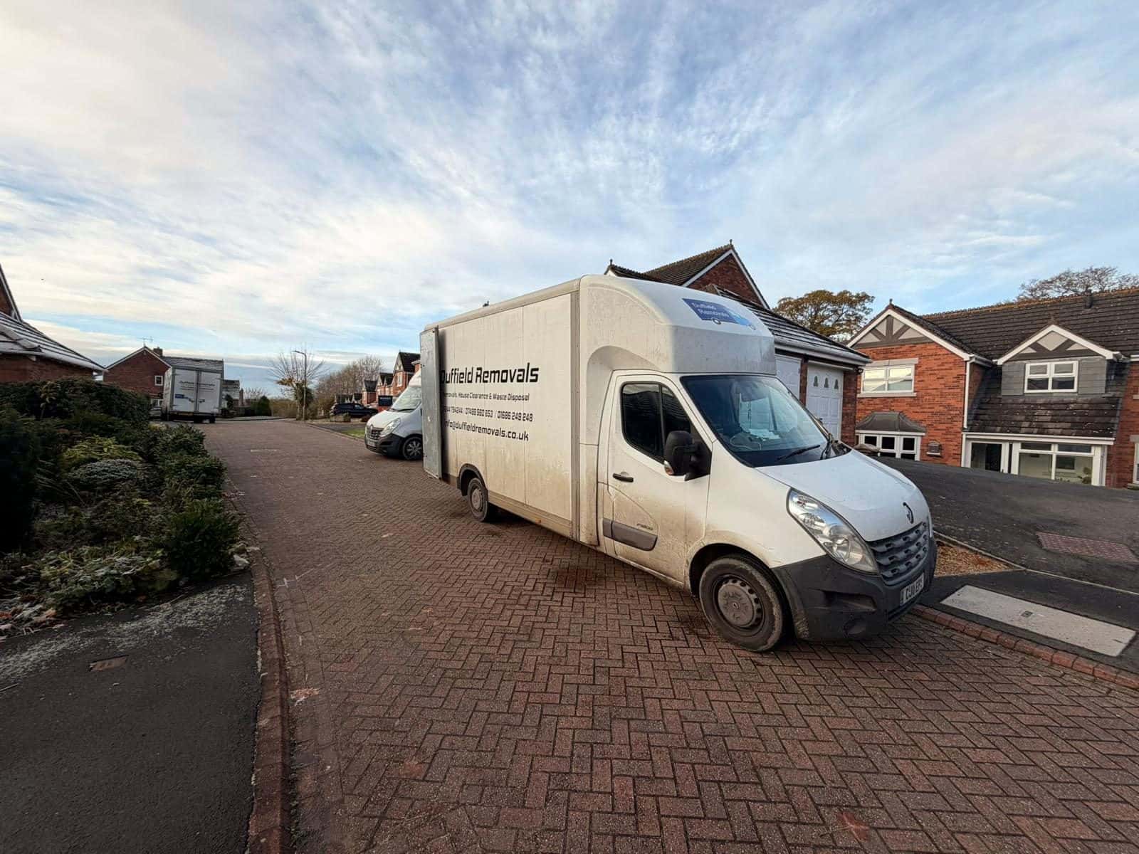 Duffield Luton van on a block-paved drive with two more vans in the street