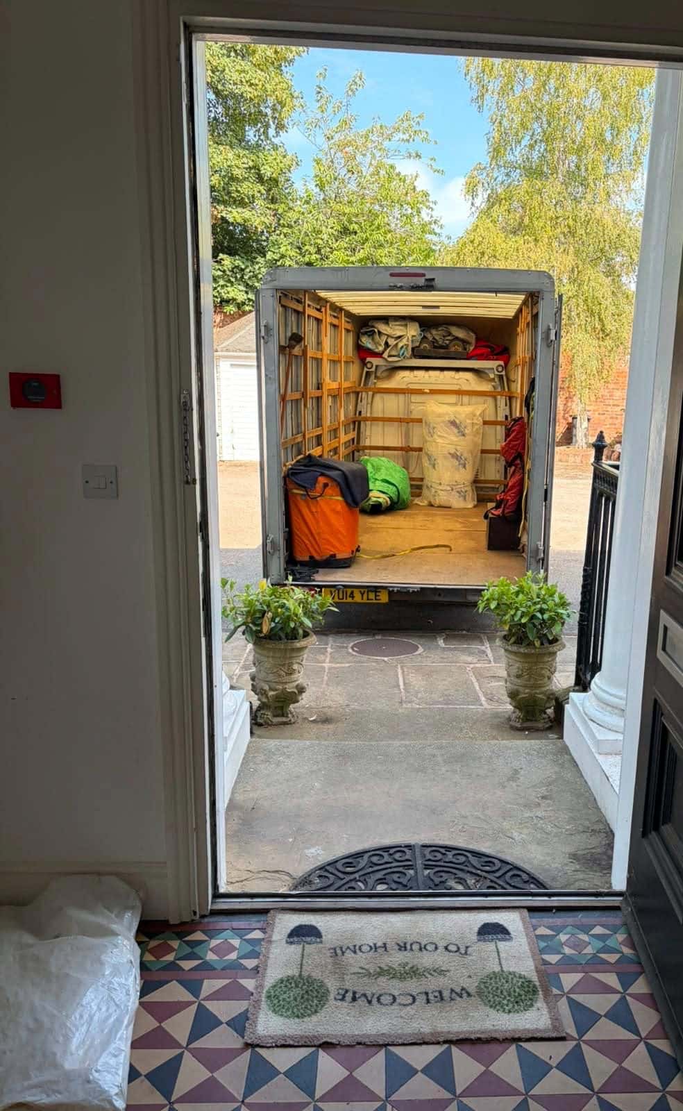 View from a tiled hallway through the front door to an open Duffield van
