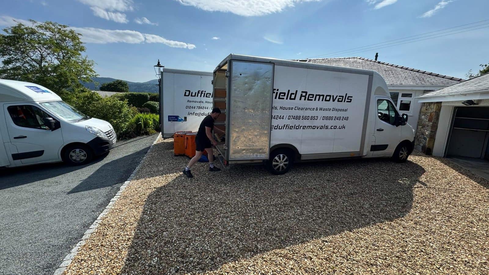 Duffield crew member pulling out a loading ramp with three vans on one house move