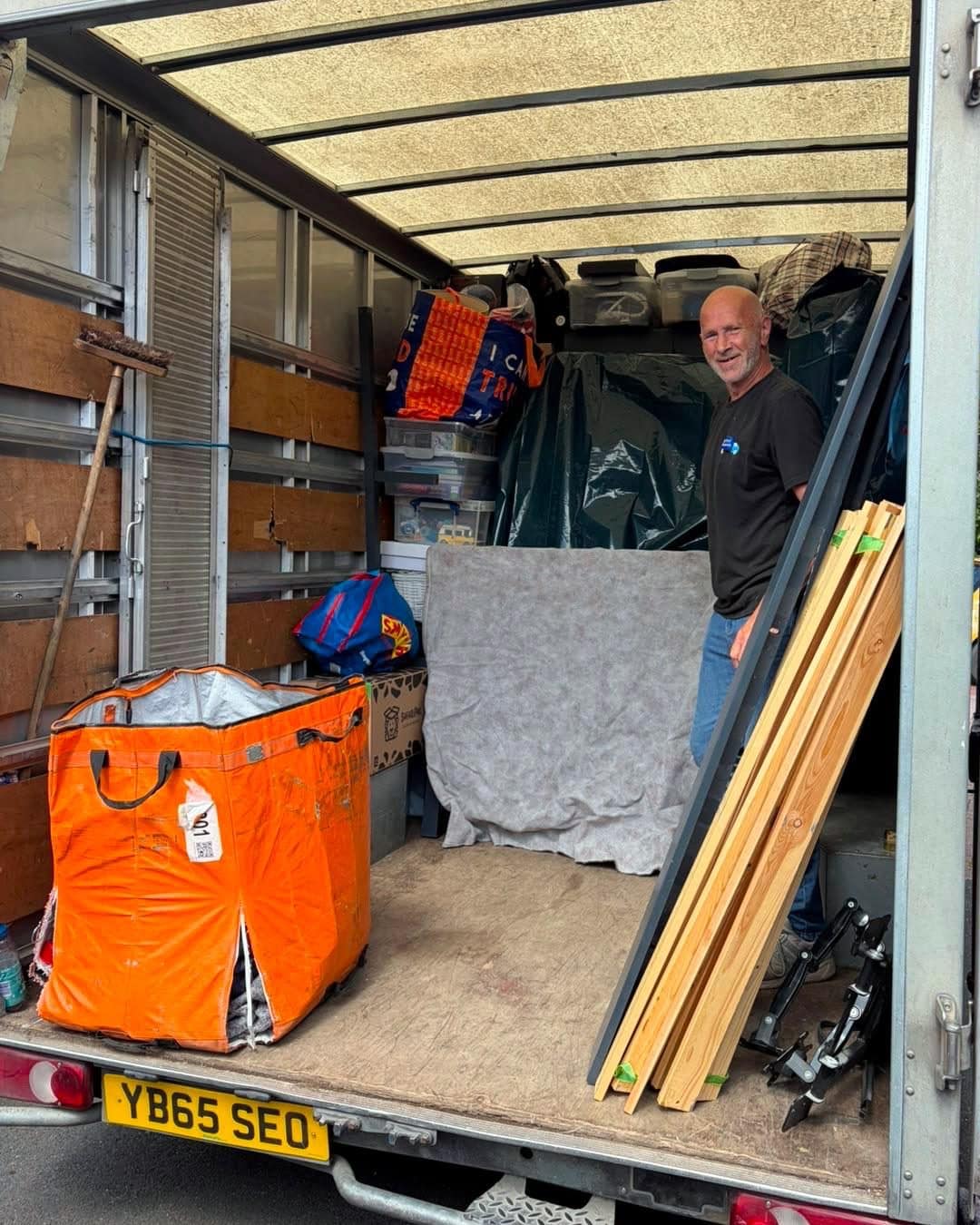 Smiling Duffield Removals crew member standing in a loaded Luton van