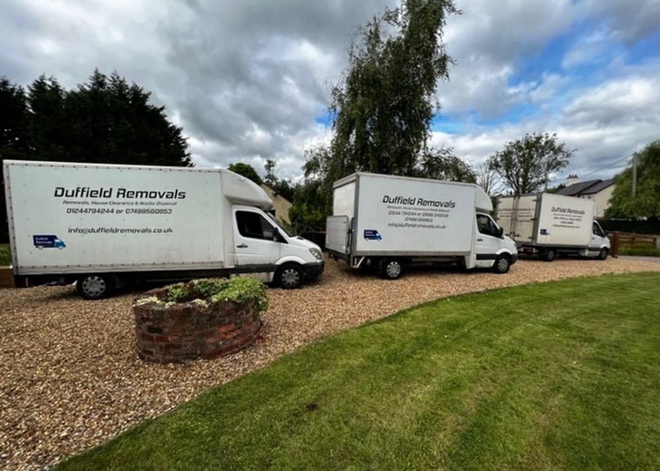 Three Duffield Removals Luton vans on a gravel drive beside a lawn