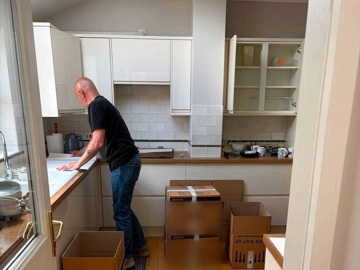 Duffield packer boxing up a kitchen, with taped cartons ready on the oak floor
