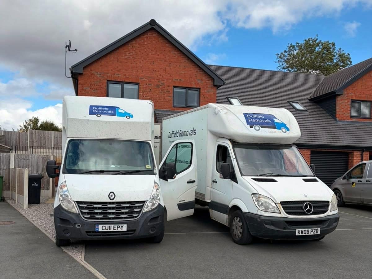 Two Duffield Removals Luton vans on the drive of a new-build home in Powys