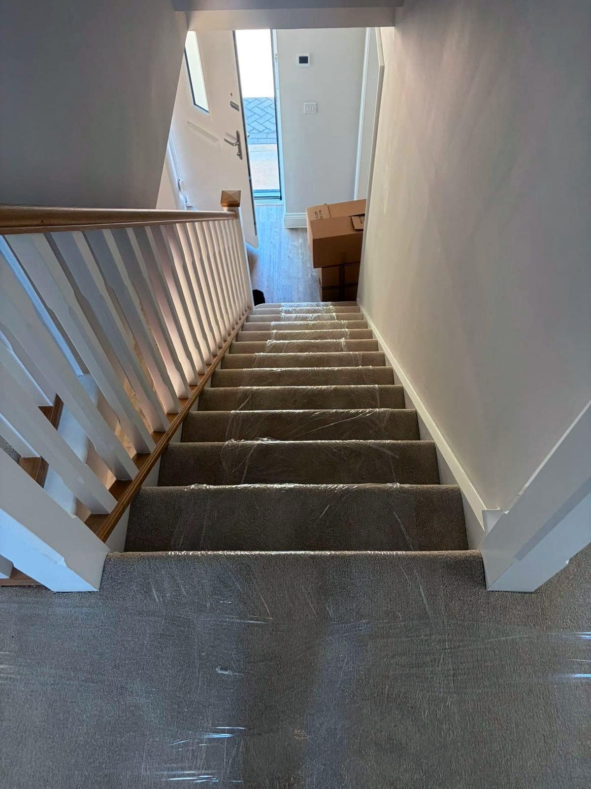 Stairs and landing covered in clear carpet protection film before furniture is carried down