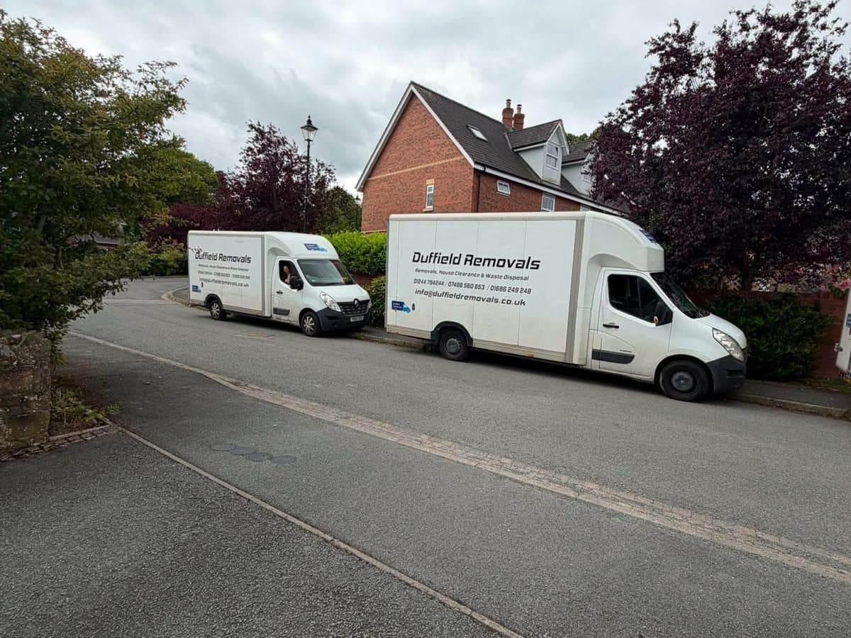 Two Duffield Removals Luton vans parked nose to tail on a leafy residential road